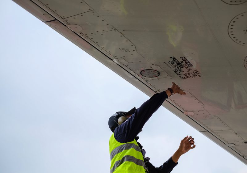 An employee inspects an airplane for maintenance in Macon.
