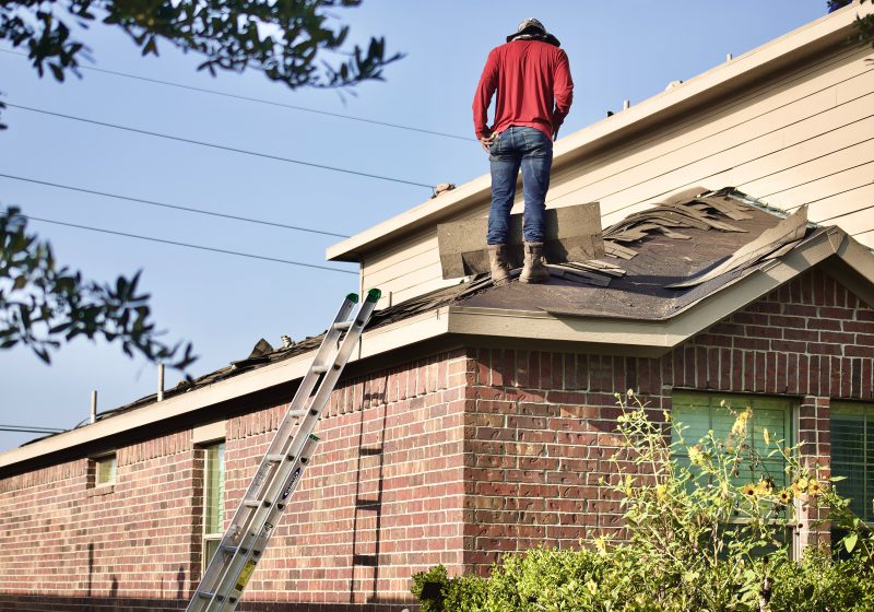 A man works on replacing a roof in Macon.